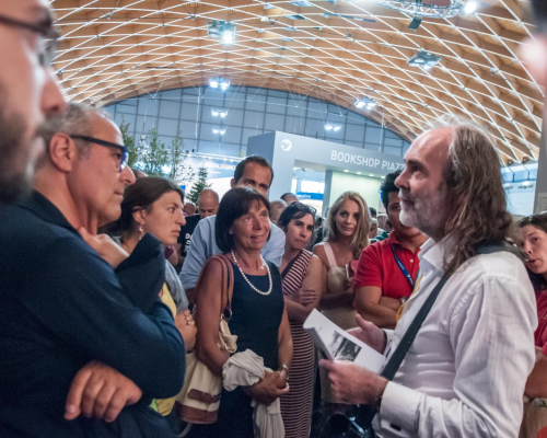 Image of John explaining the exhibits at Love & Beauty exhibition, Meeting of Rimini, 2015
